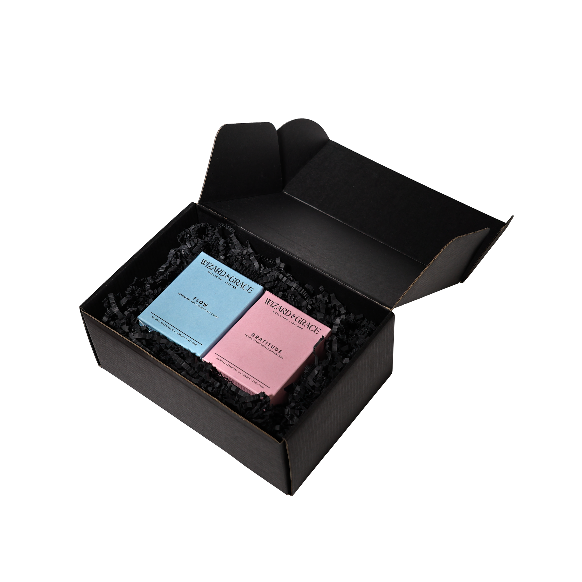 Flow and Gratitude Essential Oil Candles by Wizard & Grace placed in black recycled box packaging.